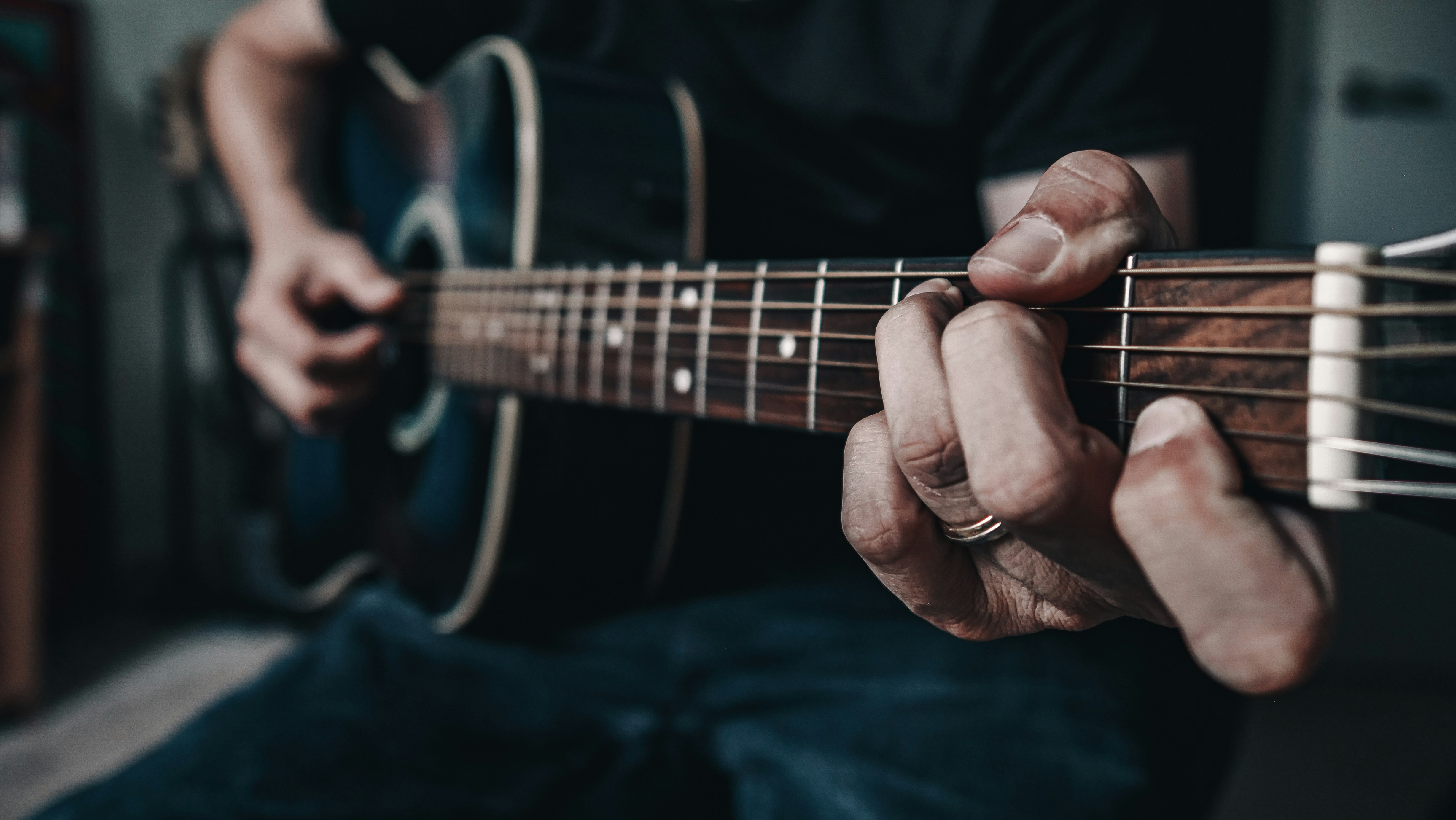 Man playing riffs on a guitar. Photo by Grant Davies on Unsplash