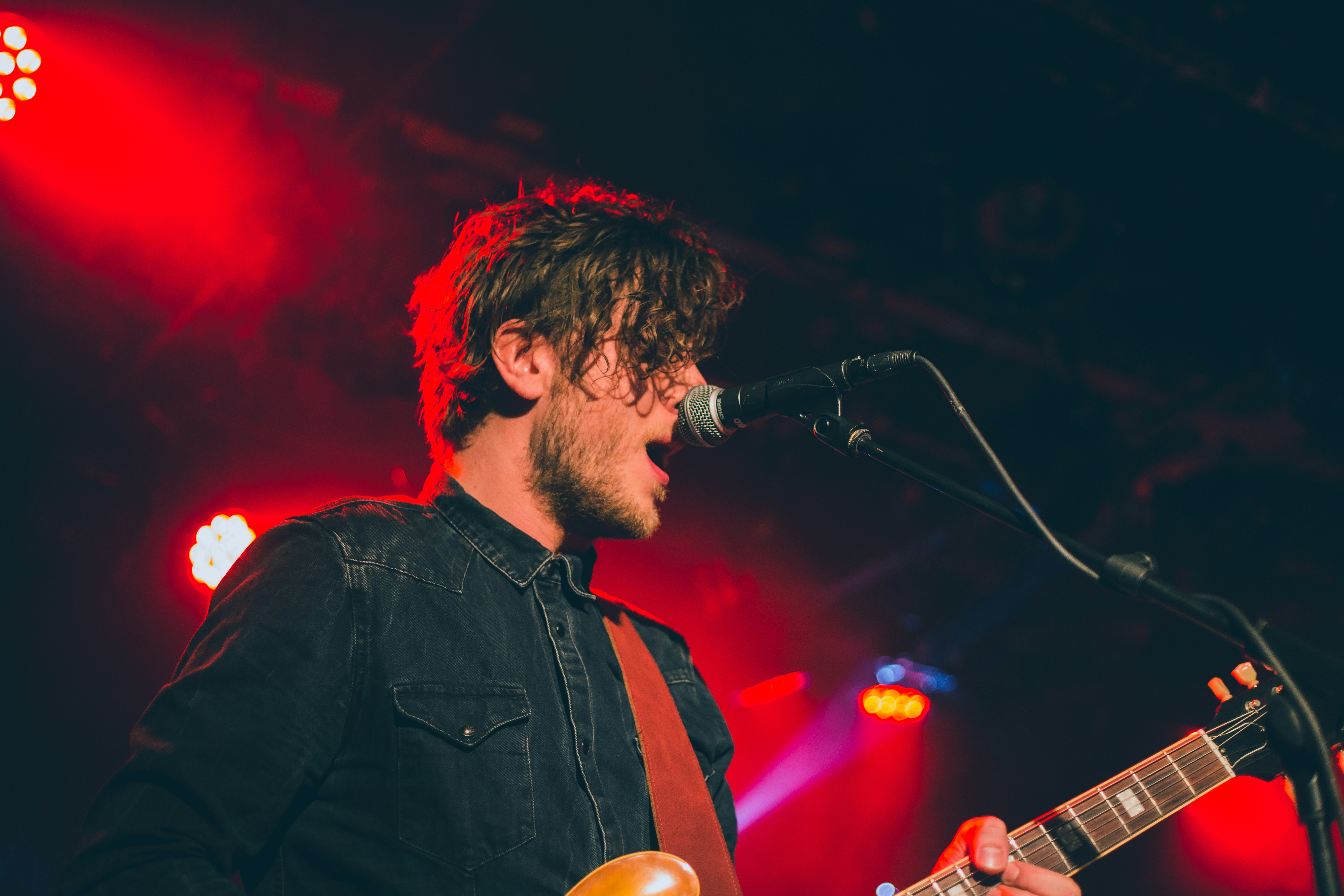 Man singing in a live concert with guitar