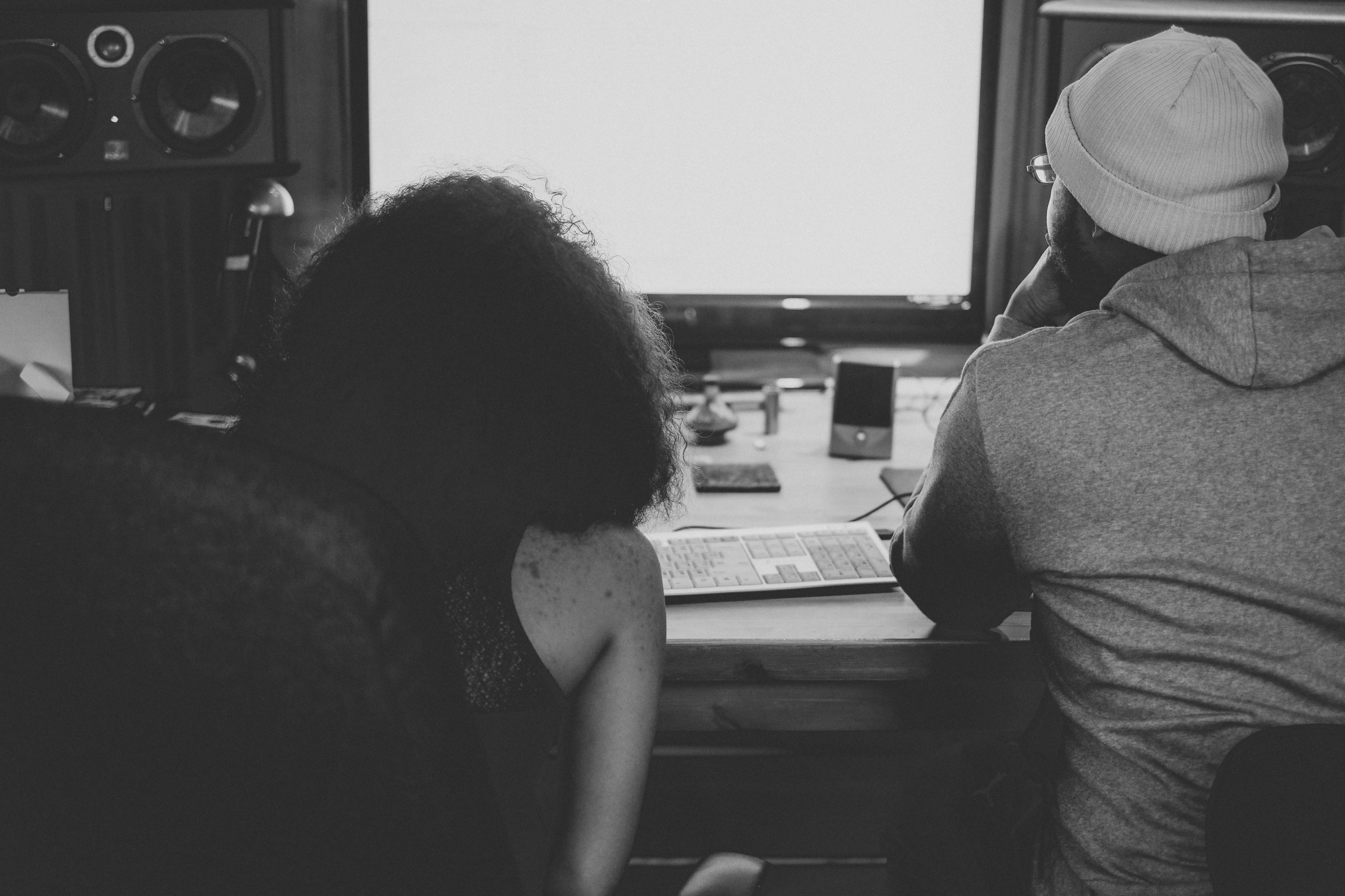 Man and woman sitting in front of a studio setup Photo by Yohann LIBOT on Unsplash