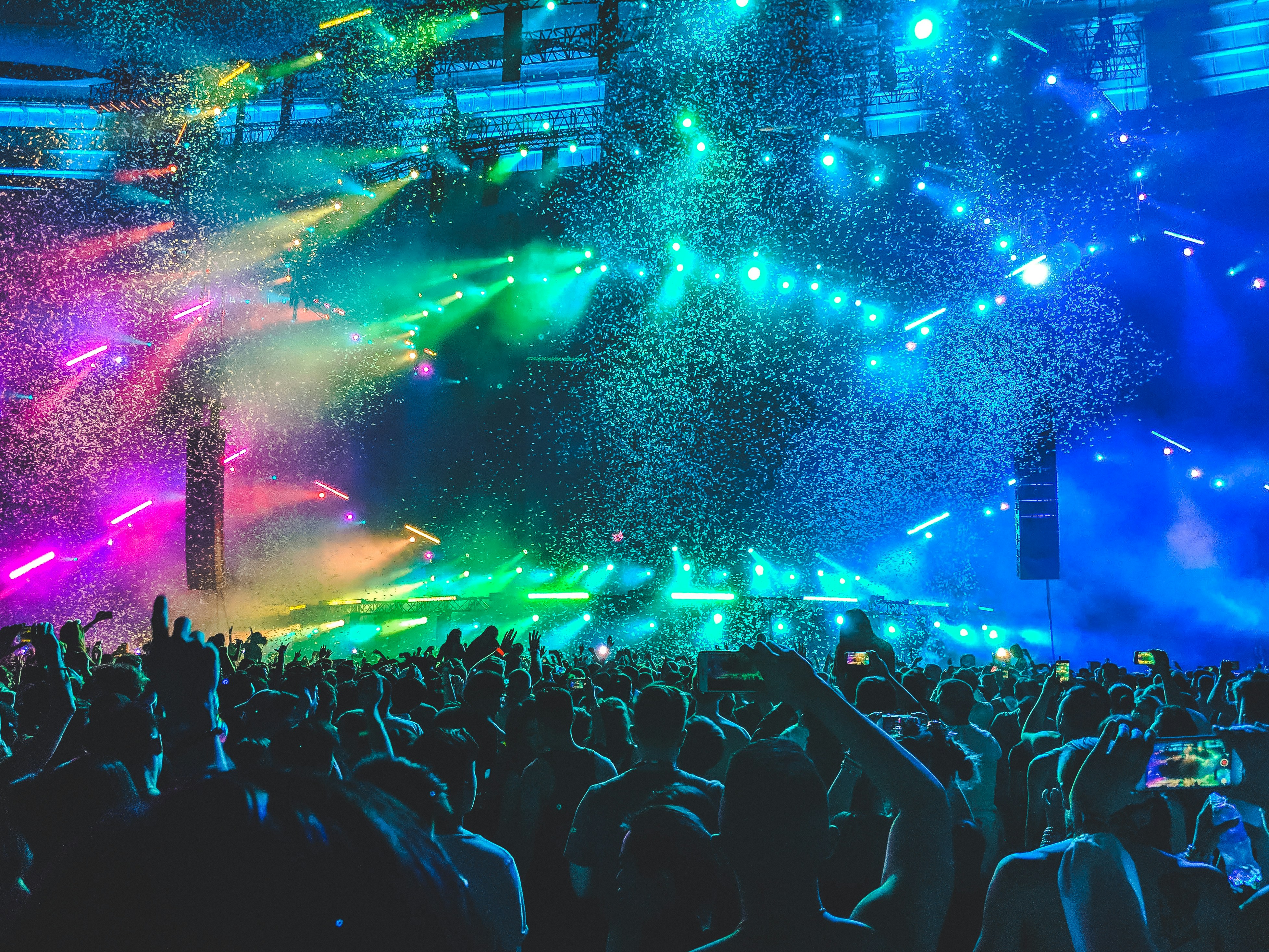 A colorful open concert with neon lights and crowds