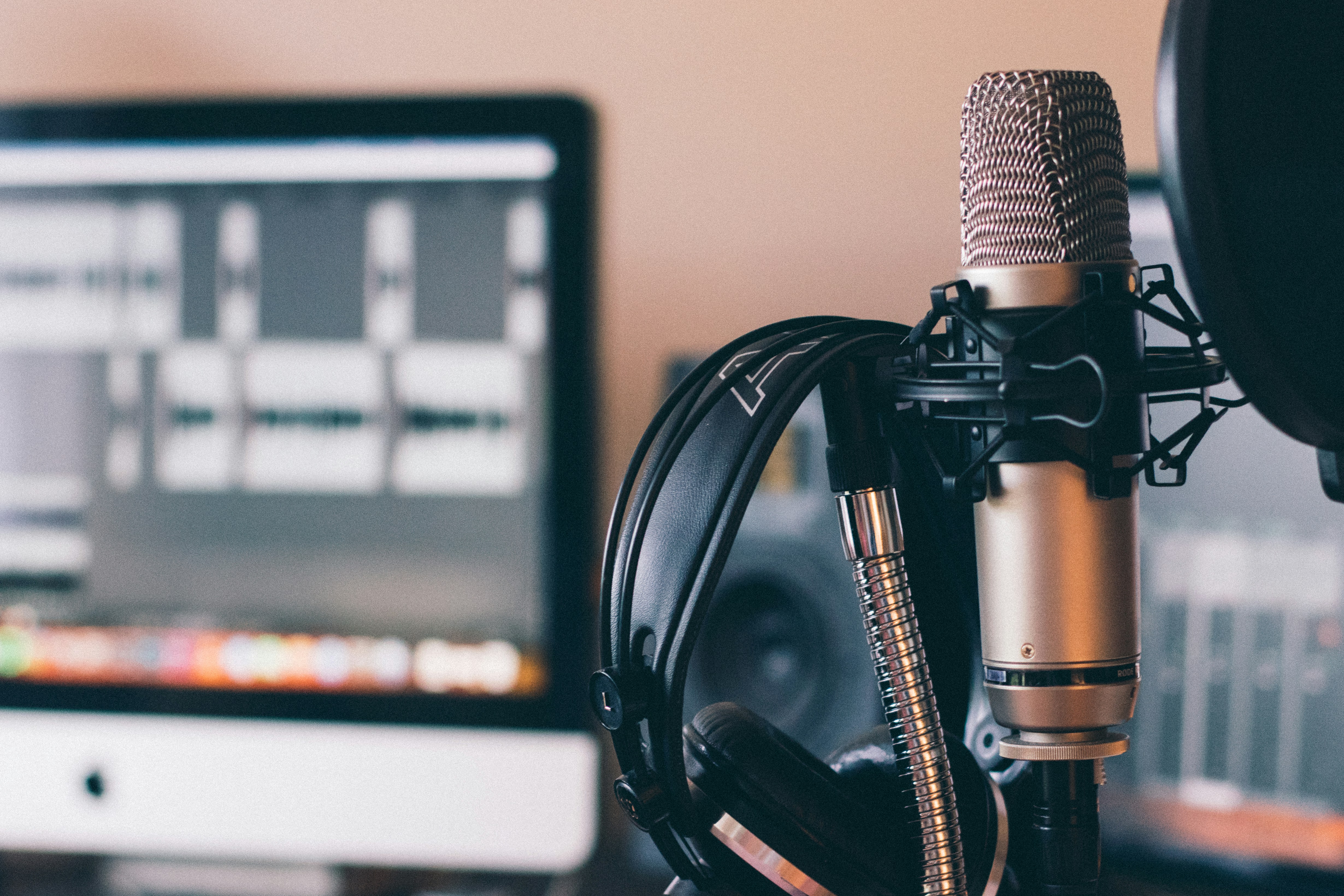 Mic and headphones in front of a music recording and open DAW software