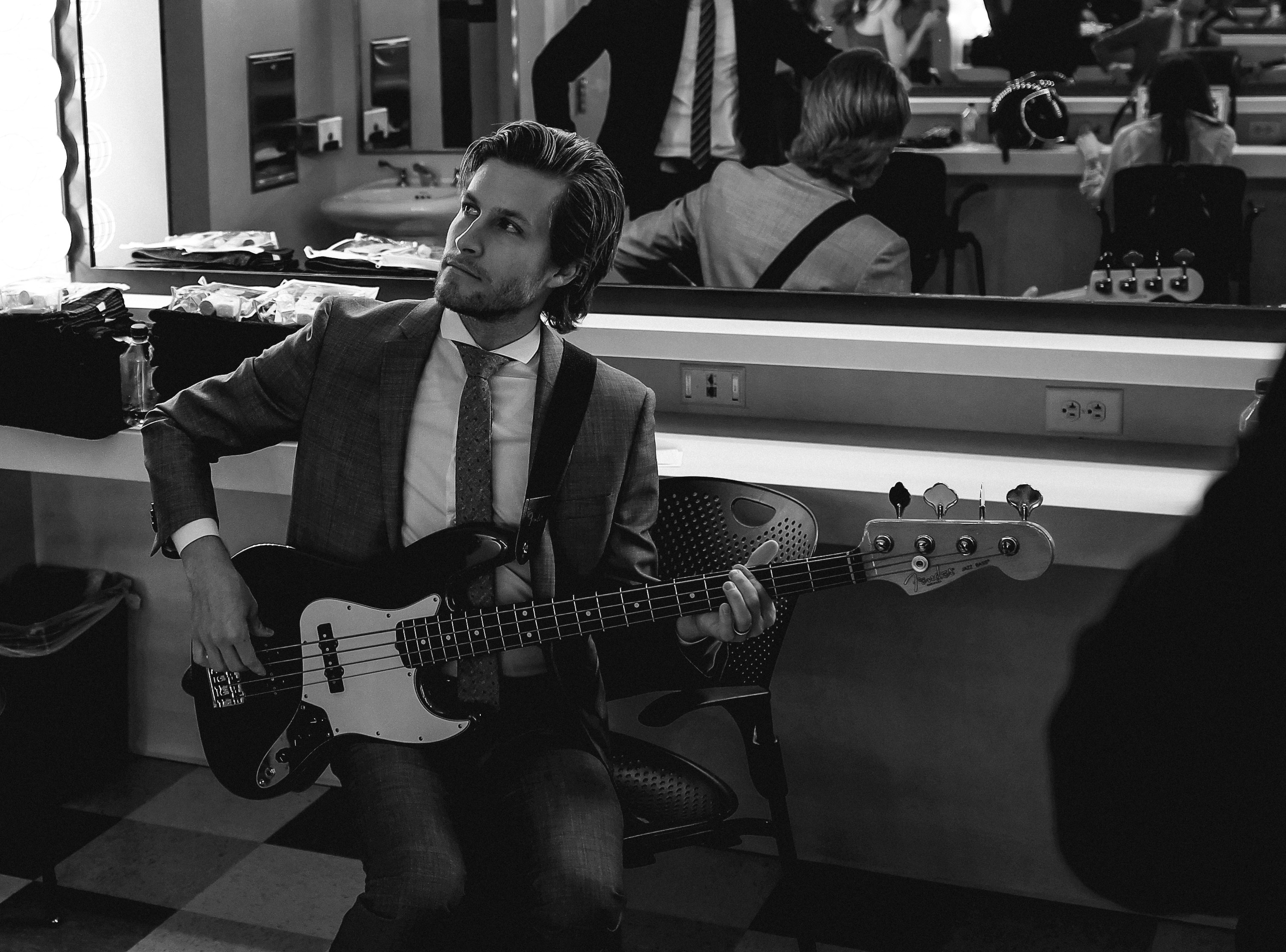 Man playing electric guitar in green room