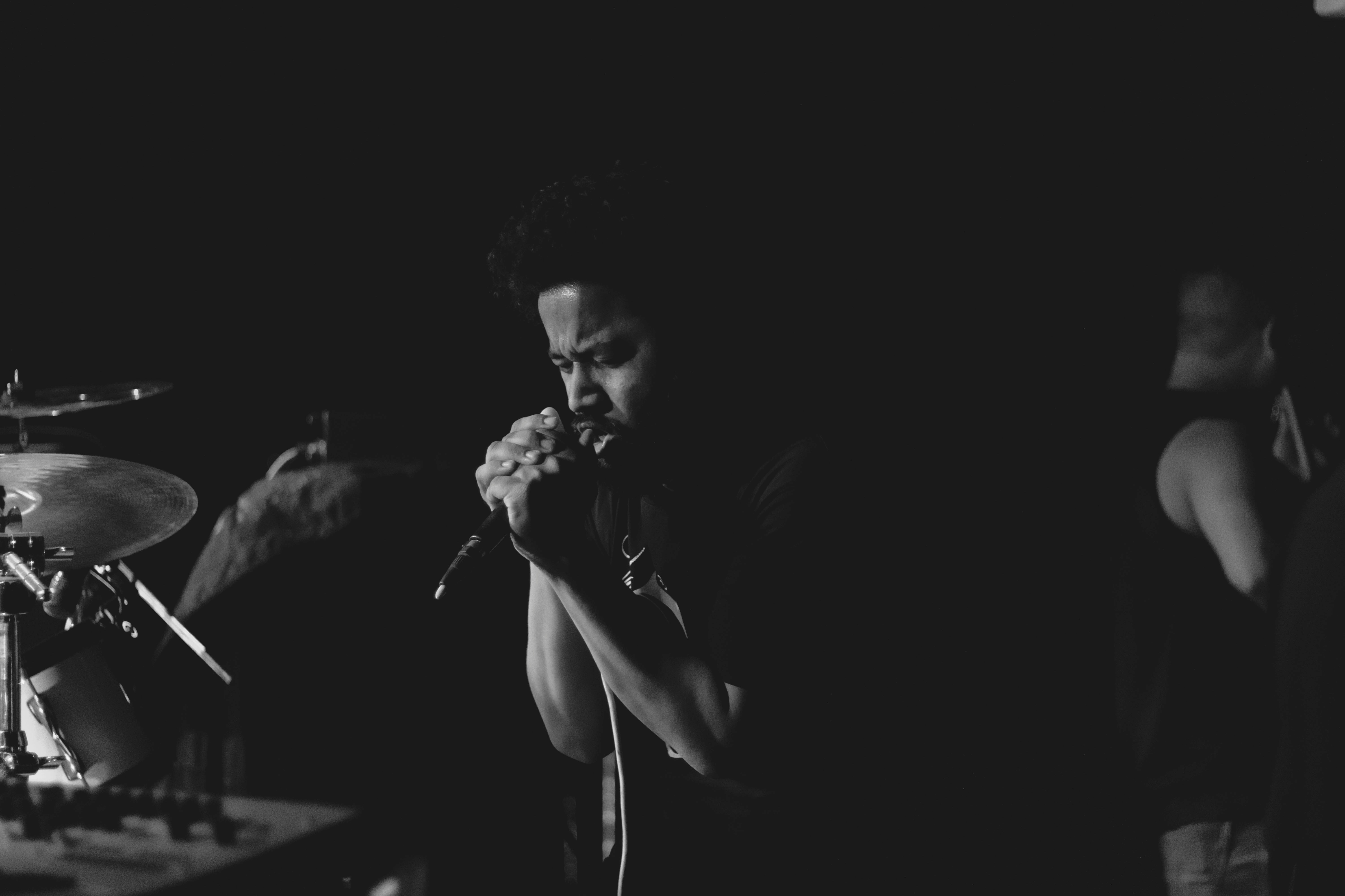 Man singing into mic during a band session. Photo by Dev Asangbam on Unsplash