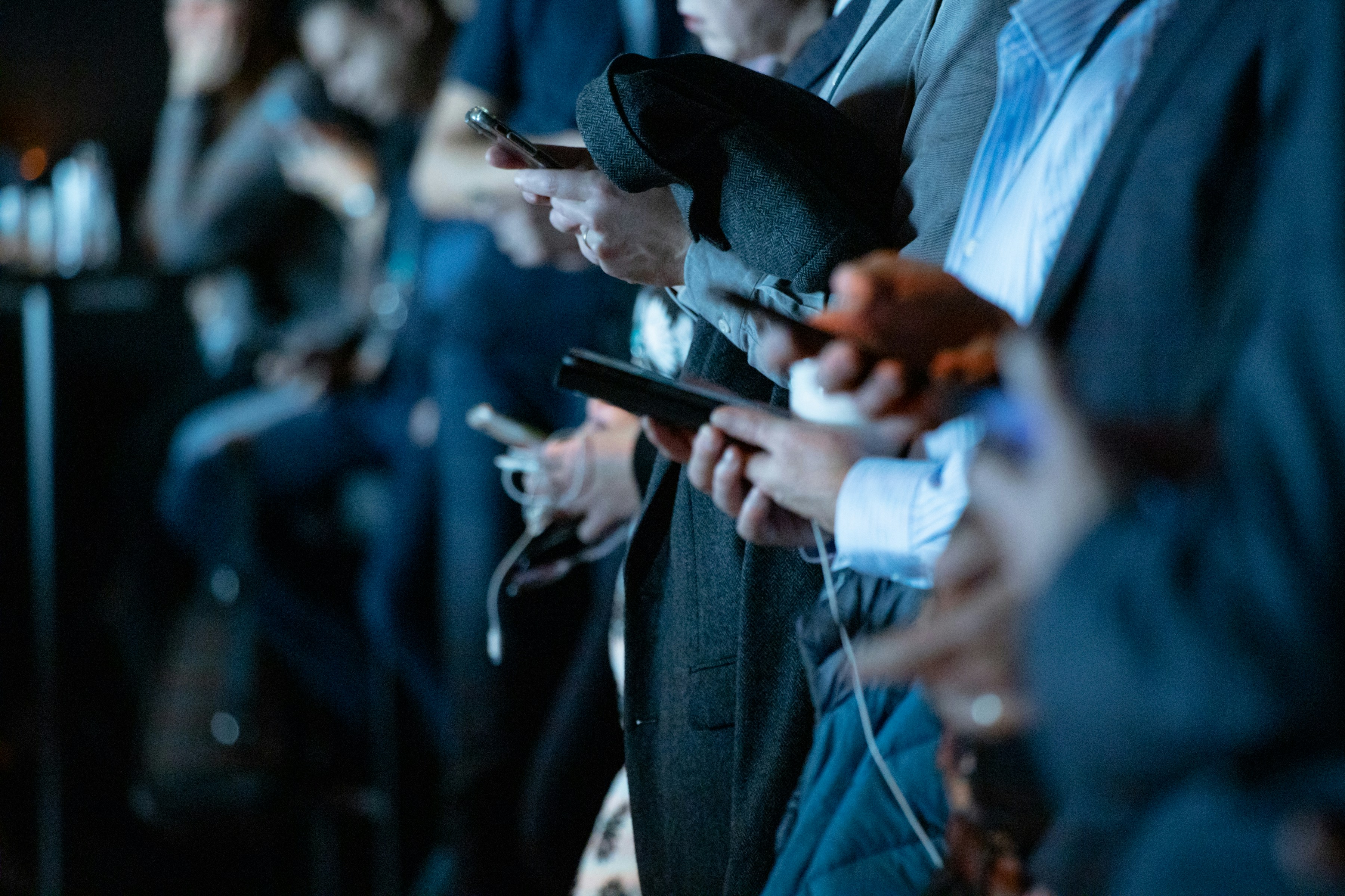 People standing in a line on their phones