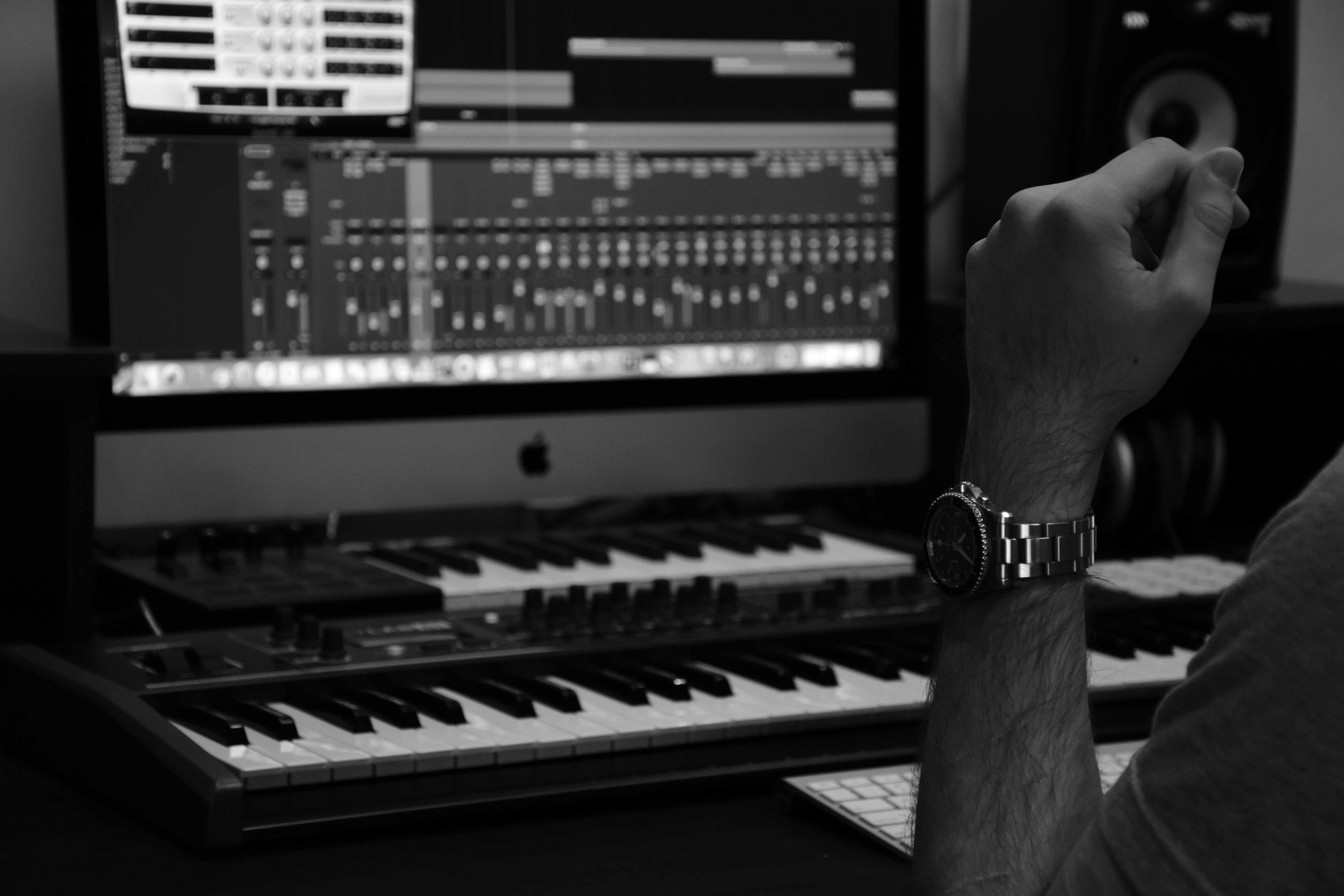 A person producing music with a MIDI keyboard and open DAW. Photo by Amin Asbaghipour on Unsplash
