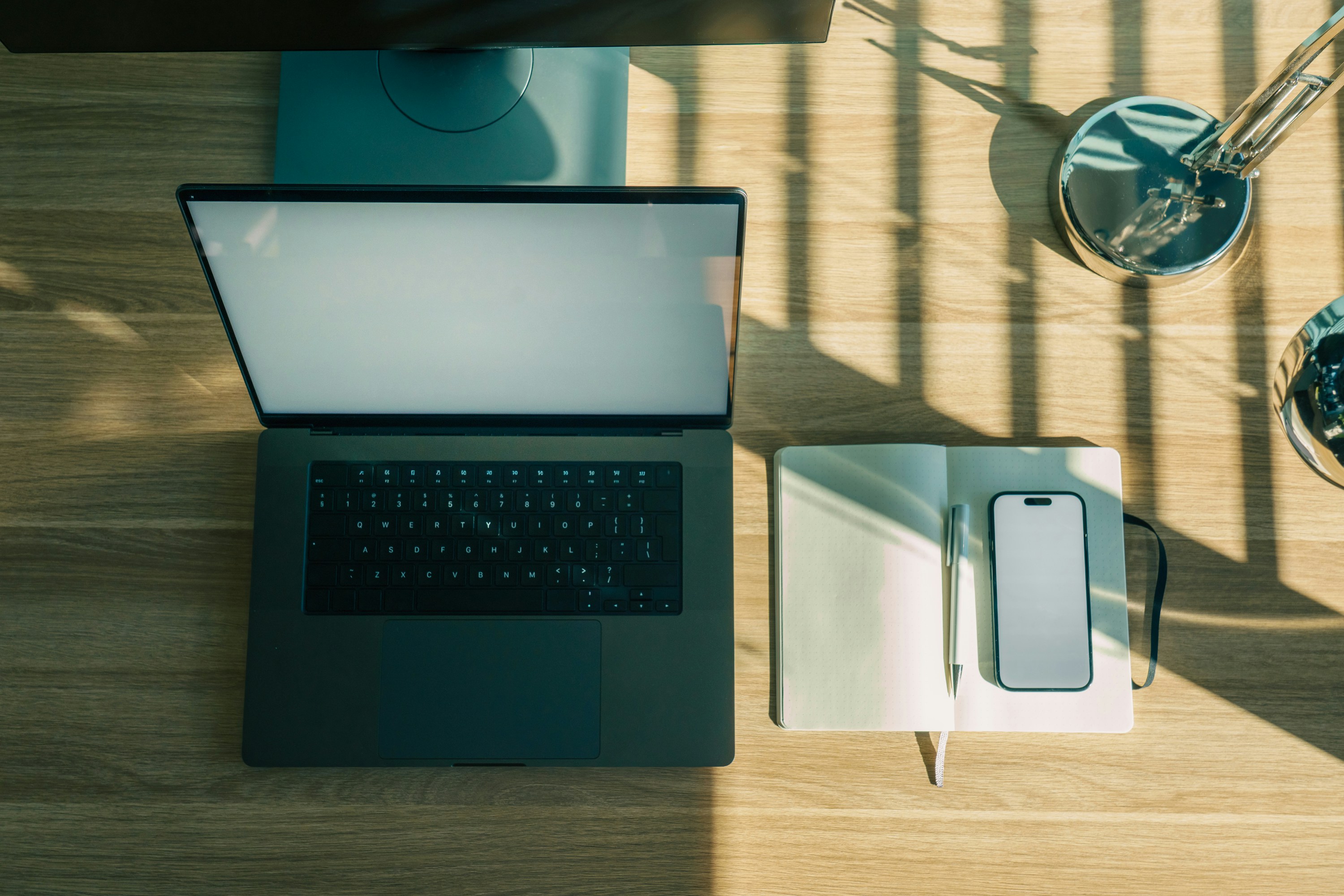 Overhead view of a laptop and phone. Photo by Jakub Żerdzicki on Unsplash